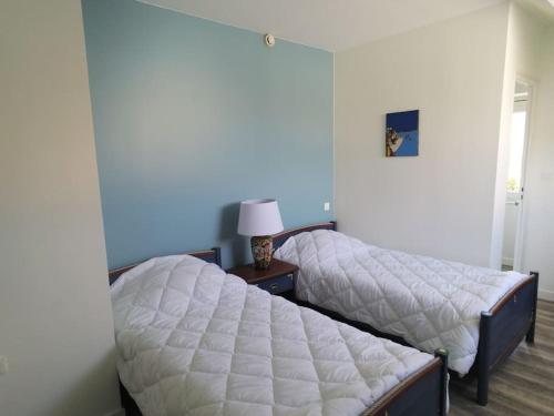 une chambre avec deux lits et une table avec une lampe dans l'établissement Magnifique logement vue mer : BELLE ILE, à La Bernerie-en-Retz
