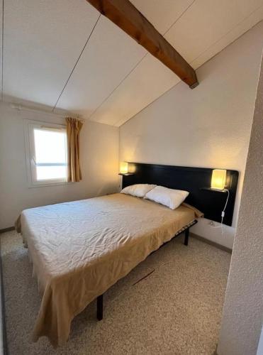 une chambre avec un grand lit avec une fenêtre dans l'établissement Diste pavillon, à Vendres