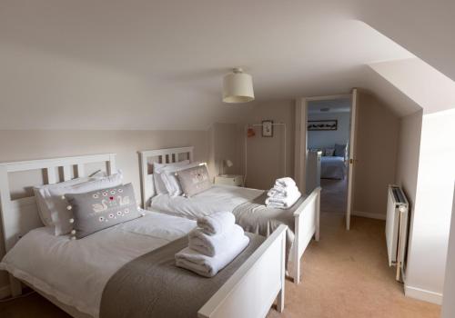 a bedroom with two beds with towels on them at Jasmine Cottage, sleeps 6 near Elie, with garden in Fife