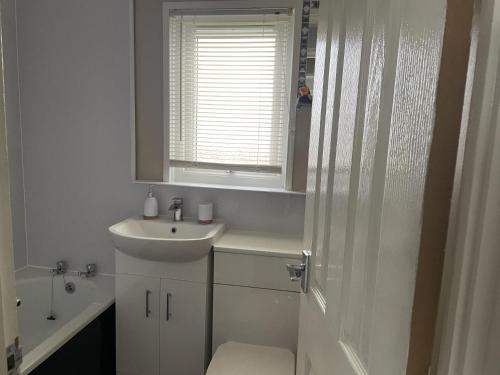 a bathroom with a sink and a toilet and a window at Captivating 2-Bed Chalet in Great Yarmouth in Great Yarmouth