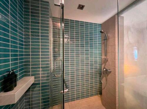 a green tiled bathroom with a glass shower at Koh Chang Appartment 2 bedrooms in Ban Bang Bao