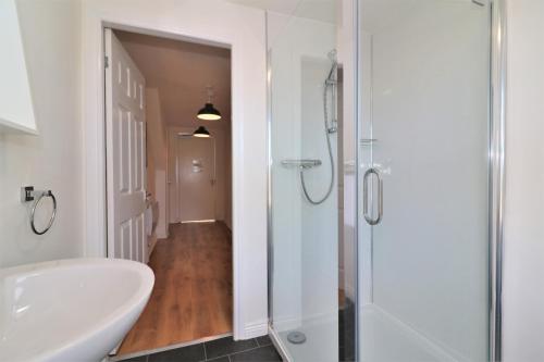 a bathroom with a shower and a sink and a toilet at Signature - No 11 Bonnet Apartments in Lanark