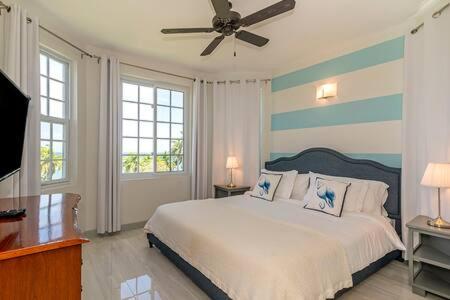 a bedroom with a bed and a ceiling fan at Ultra Modern 2BR Penthouse, Sleeps 5, Beach Front, Pool, Roof Patio, Montego Bay in Montego Bay