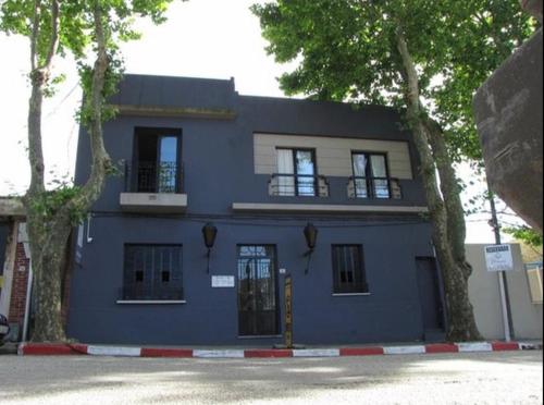 a blue building with two windows and a door at Posada Boutique Le Vrero in Colonia del Sacramento