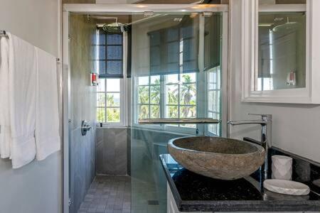 a bathroom with a large stone sink and a shower at Ultra Modern 2BR Penthouse, Sleeps 5, Beach Front, Pool, Roof Patio, Montego Bay in Montego Bay