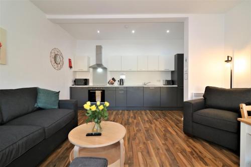 a living room with a couch and a table with flowers at Signature - No 1 Bonnet Apartments in Lanark