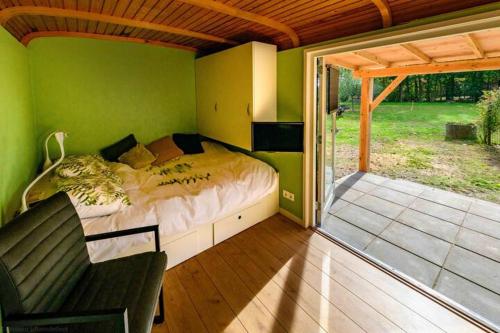 a bedroom with a bed in a green wall at Tinyhouse De Woord in Corle