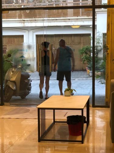 a couple of people walking in a room with a table at White House Guesthouse in Phnom Penh