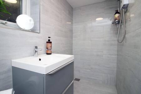 a white bathroom with a sink and a shower at River View by Afan Valley Escapes in Port Talbot