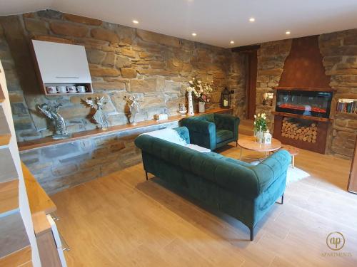 sala de estar con sofá verde y pared de piedra en Istrian Perfect Life, en Šmarje