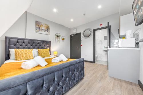 um quarto com uma cama grande com almofadas amarelas e brancas em Captivating Serviced Room Sydenham London SE26 em Londres