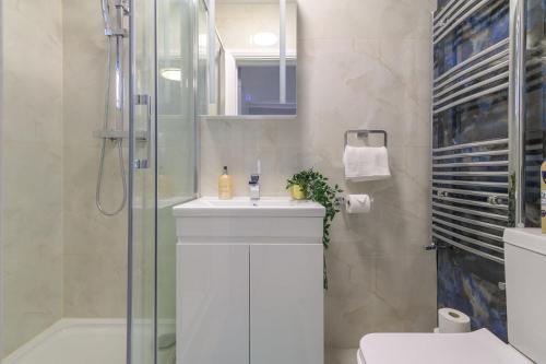 a bathroom with a white sink and a shower at 12 Elmwood in Harrow