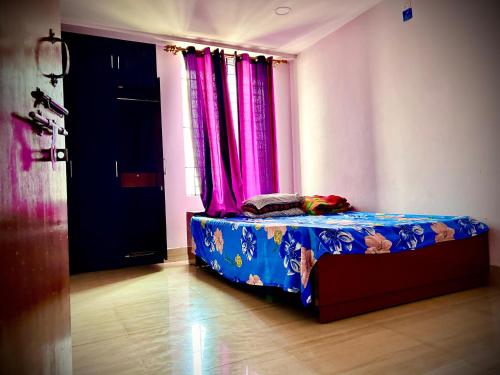 Ce lit se trouve dans un dortoir doté de rideaux roses. dans l'établissement Angel guest house, à Guwahati