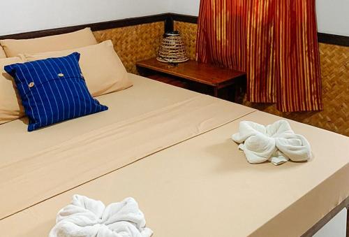 a bedroom with two towels on a bed at RedDoorz @ Tandikan Beach Cottages in El Nido