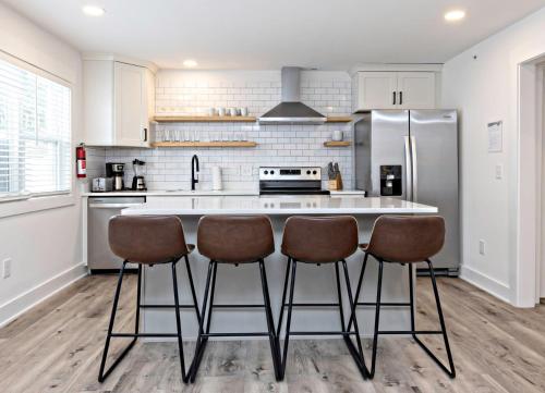 a kitchen with a large island with bar stools at Ocean Lofts in the Vibe #1 - 5 min walk to beach in Virginia Beach