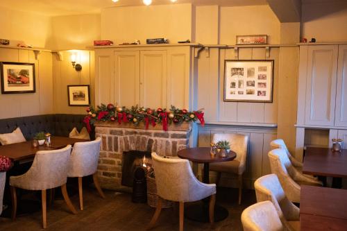 a restaurant with a fireplace and tables and chairs at The Dog in Over Peover in Knutsford