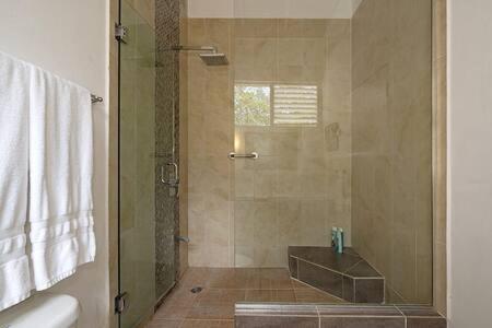 baño con ducha y puerta de cristal en Hospitality Expert Zeppelin - Tour Pool Bar Beach, en Montego Bay