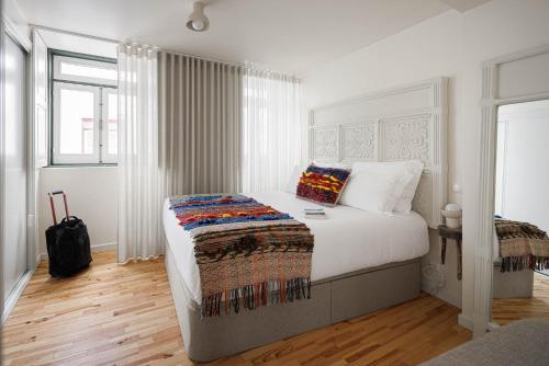 1 dormitorio con 1 cama grande con sábanas blancas y ventana en Story Studio Coimbra Centro, en Coímbra