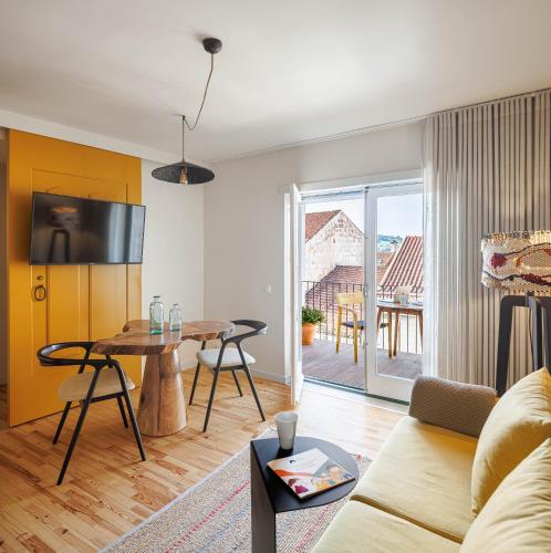 a living room with a couch and a table at Story Studio Coimbra Centro - Culture in Coimbra