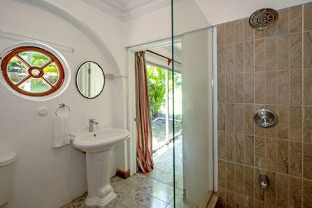 a bathroom with a sink and a shower with a window at Hospitality Expert Madonna Tour Pool Bar Beach in Montego Bay