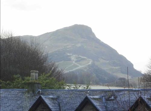 a view of a mountain with a house in front at Stunning 2 Bed Apt in Edinburgh - Incredible views in Edinburgh
