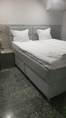 a bed with white sheets and pillows on it at Boutique Guest House"Ruvan" in Burgas City