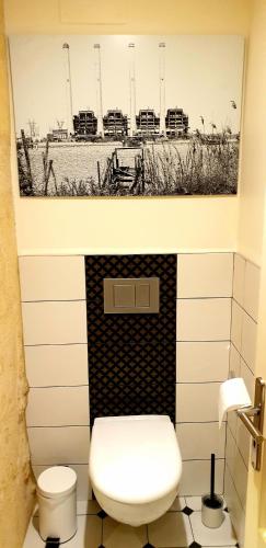 une salle de bain avec toilettes et un tableau au mur dans l'établissement La maison d artiste, à Saint-Émilion