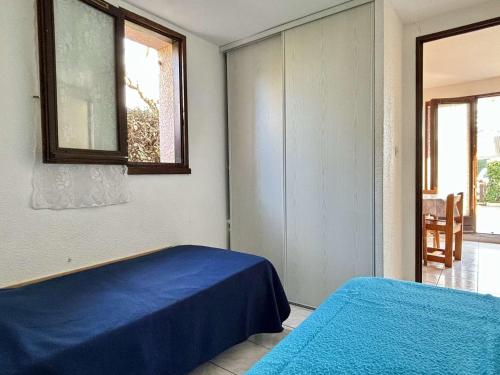 une chambre avec deux lits et une fenêtre dans l'établissement Maison 2 pièces avec mezzanine, piscine et parking privés, 6 couchages à 700m de la plage - Argelès-sur-Mer - FR-1-225-74, à Argelès-sur-Mer