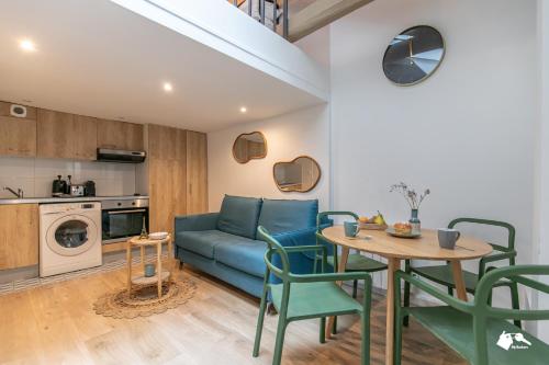 un salon avec un canapé bleu, une table et des chaises dans l'établissement MBA - Splendide Appart - Gambey 2 - Proche République, à Paris