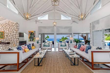 a large living room with white couches and tables at Hospitality Expert Eden 7BR Pools Beach in Montego Bay