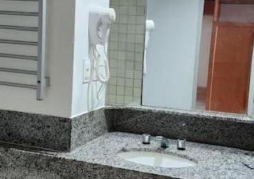 Un baño con un lavabo con un teléfono en la pared. en Praia de Piedade flat frente para o mar, completo Edf Golden Beach, en Recife