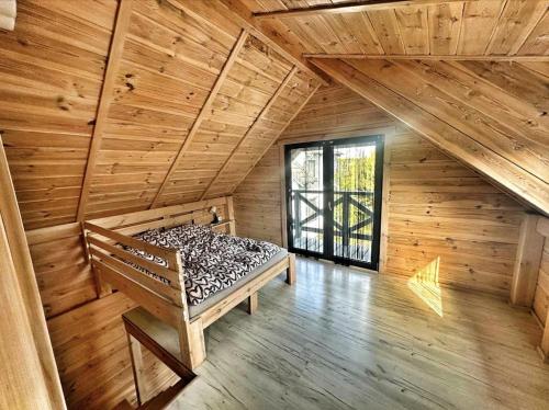 ein Zimmer mit einer Bank in einer Holzhütte in der Unterkunft Sosenkowe Zacisze Wiele in Wiele