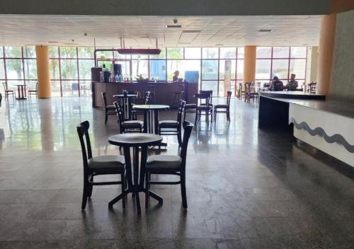 Un restaurante con mesas y sillas y un bar. en Praia de Piedade flat frente para o mar, completo Edf Golden Beach, en Recife