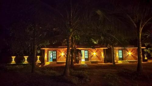 a house with lights on the front of it at night at Saka kadams home stay in Guhagar