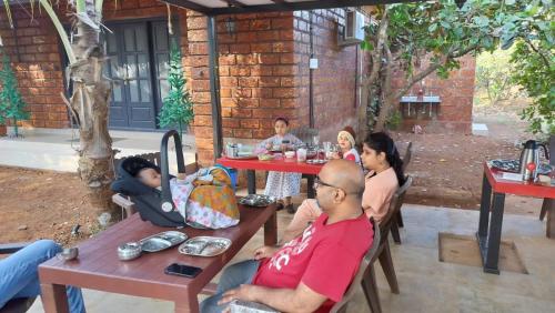 a group of people sitting at tables at a restaurant at Saka kadams home stay in Guhagar