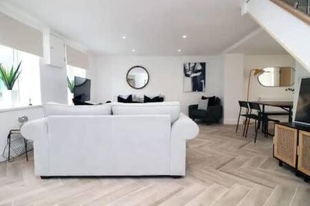 a white living room with a white couch and a table at Treorchy Terrace by StayStaycations in Treorky