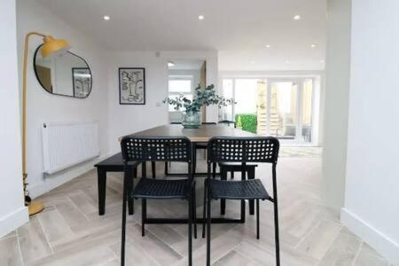 a dining room with a black table and chairs at Treorchy Terrace by StayStaycations in Treorky