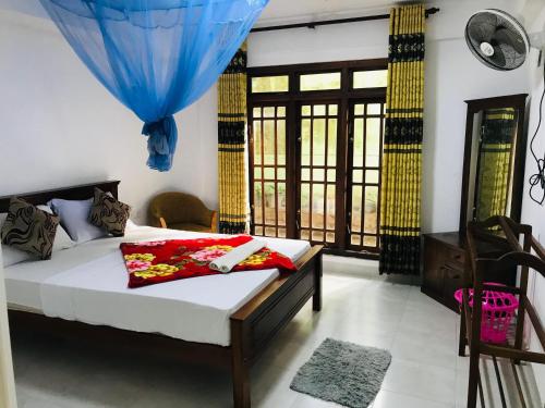 a bedroom with a bed in a room with windows at Ella Jayamali Holiday Pavilion in Ella