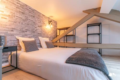 un grand lit dans une pièce avec un mur de briques dans l'établissement MBA - Splendide Appart - Gambey 2 - Proche République, à Paris