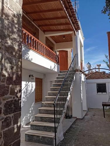 a stairway leading to a white building with a wooden roof at La Nature in Konístrai