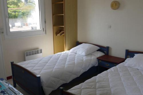 - une chambre avec deux lits à côté d'une fenêtre dans l'établissement Appartement 4/6 pers accès plage direct : Batz, à La Bernerie-en-Retz