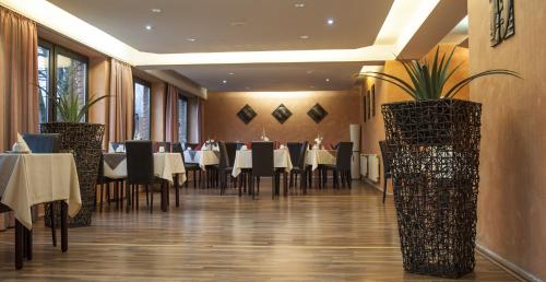 a dining room with tables and chairs and plants at Stargaze Home Hotel in Haan