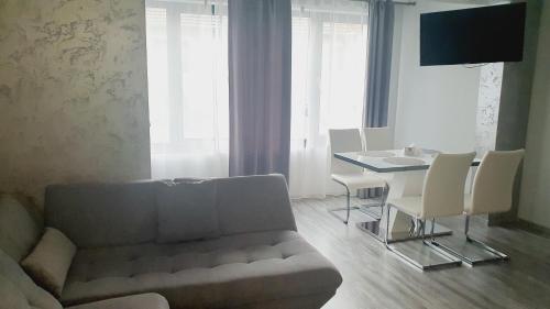 a living room with a couch and a table with chairs at Boutique Guest House"Ruvan" in Burgas City