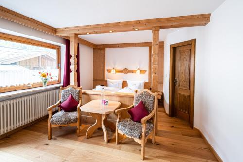 a room with a table and two chairs and a bed at Birgsau in Oberstdorf