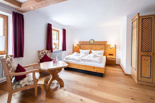 a bedroom with a bed and a table and chairs at Birgsau in Oberstdorf