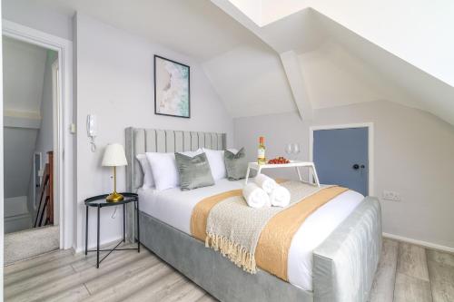 a white bedroom with a large bed with white pillows at 12 Elmwood in Harrow