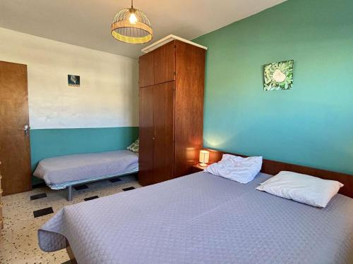 een slaapkamer met een bed en een kast en een bed sidx sidx sidx bij Appartement Port-la-Nouvelle, 2 pièces, 5 personnes - FR-1-229C-495 in Port-la-Nouvelle