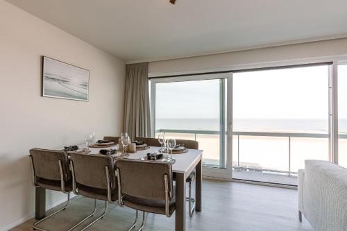 a dining room with a table and chairs and a large window at Beautiful Luxury Apartment on Amazing location with Sea view - T17 in Ostend