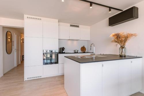 a kitchen with white cabinets and a sink at Beautiful Luxury Apartment on Amazing location with Sea view - T17 in Ostend