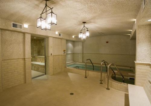 a bathroom with a swimming pool and two lights at Griffin Hotel, an official Colonial Williamsburg Hotel in Williamsburg